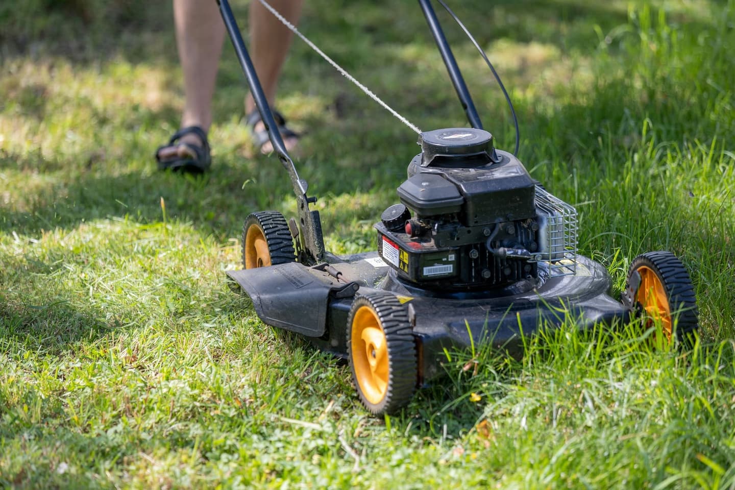 Maintenance worker mowing a residential lawn